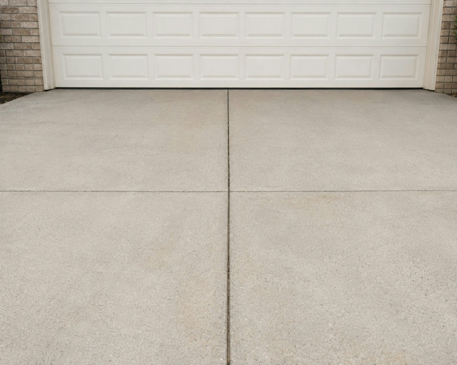 Close-up of a broom-finished concrete driveway with control joints